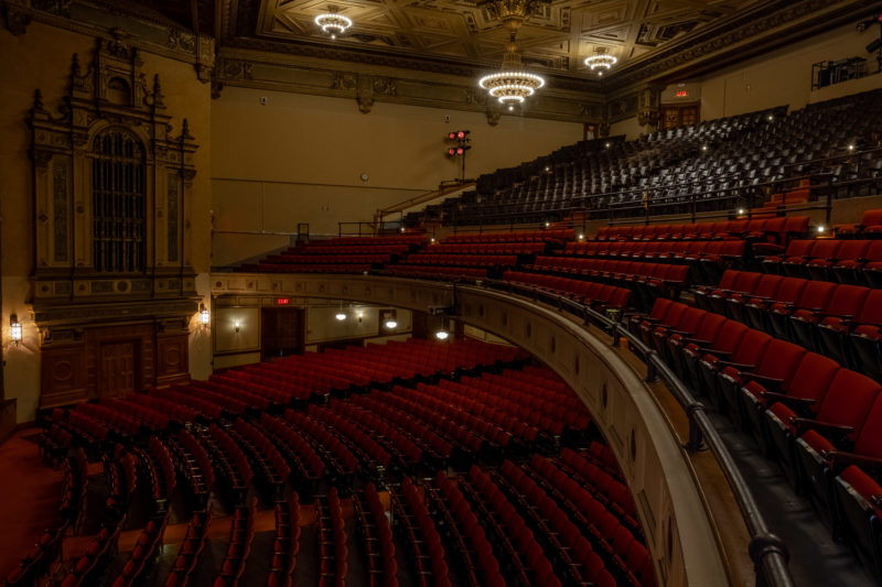 Side view of the red upholstered chairs of the orchestra, loge and balcony at the Sydney Goldstein Theater